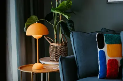 a lamp on a table next to a chair and a plant at Stylish 2-Bedroom Escape near Dubai Mall in Dubai