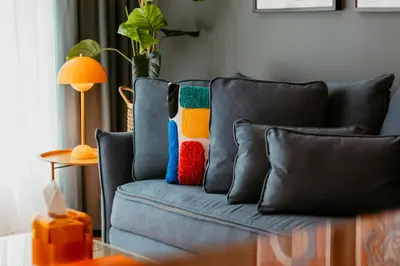 a blue couch with colorful pillows on it at Stylish 2-Bedroom Escape near Dubai Mall in Dubai