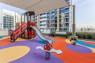 a play area with a slide and a playground at Tranquil Studio Retreat in Azizi 34 Near Downtown in Dubai