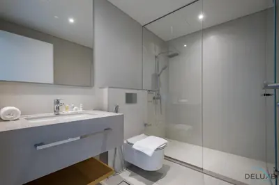 a bathroom with a toilet and a sink and a shower at Elegant 2BR Apartment in La Vie, JBR by Deluxe Holiday Homes in Dubai