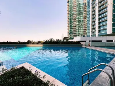 a large swimming pool in a city with tall buildings at Fabulous 1BR apartment in Address Beach Resort in Dubai