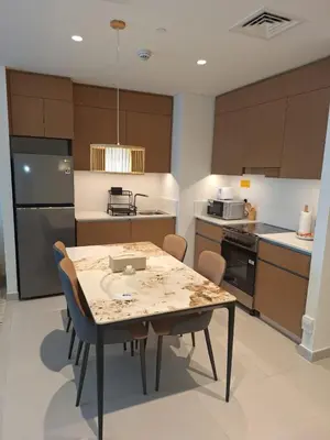 a kitchen with a table and chairs and a refrigerator at Creek Beachfront Heaven: 1BR Luxe Harbor Flat in Dubai