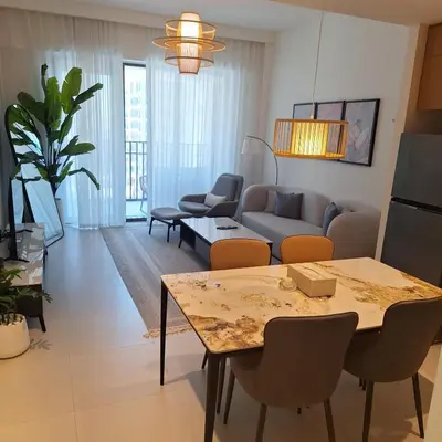 a living room with a table and a couch at Creek Beachfront Heaven: 1BR Luxe Harbor Flat in Dubai