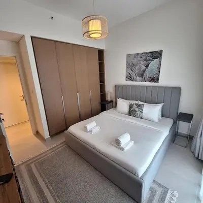 a bedroom with a bed with two pillows on it at Creek Beachfront Heaven: 1BR Luxe Harbor Flat in Dubai