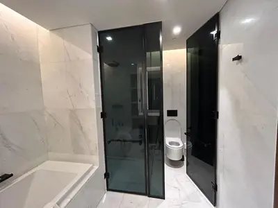 a bathroom with a shower and a tub and a toilet at Bluewaters Island - Modern 2 bedroom Full Apartment in Dubai