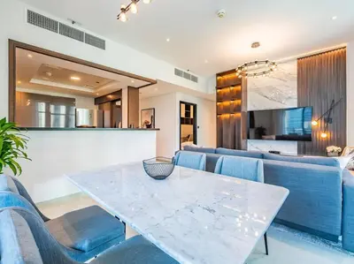 a living room with a table and blue chairs at Modern Downtown Escape 1Bedroom with Upscale Comfort in Dubai