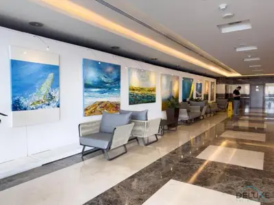 a waiting room with chairs and paintings on the wall at Modern 1BR Apartment in Elite Residences, Dubai Marina by Deluxe Holiday Homes in Dubai