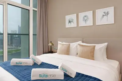 two beds in a hotel room with a window at Your Dream Home in Damac Maison Prive by Suiteable in Dubai