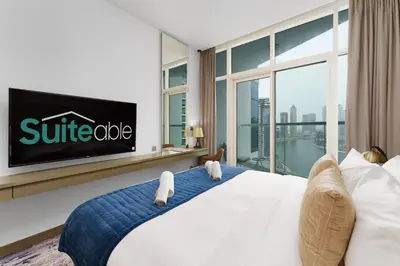 a bedroom with a large bed and a tv at Your Dream Home in Damac Maison Prive by Suiteable in Dubai