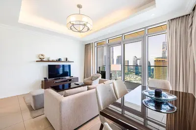 a living room with a couch and a table and chairs at The Address Fountain Views - Residence 2 Bedroom with Burj Khalifa view in Dubai