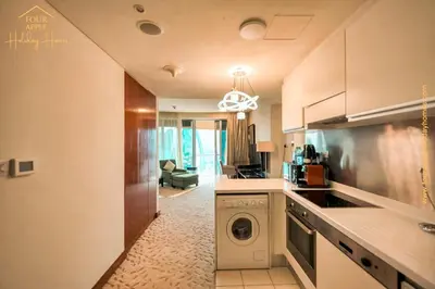 a kitchen with a washer and dryer in a room at EMAAR Residences Fashion Avenue Full Burj Khalifa views Studio in Dubai