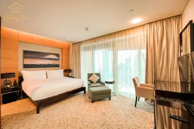 a bedroom with a bed and a chair and a television at EMAAR Residences Fashion Avenue Full Burj Khalifa views Studio in Dubai