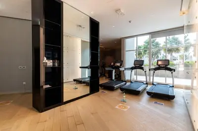 a gym with several exercise bikes and a large mirror at GuestReady - Stylish studio with Dubai Canal view in Dubai