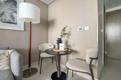 a room with a table with two chairs and a lamp at GuestReady - Stylish studio with Dubai Canal view in Dubai