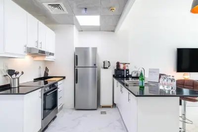 a kitchen with a stainless steel refrigerator in it at Stylish 1BR Apartment with City View Balcony Pool and Parking in Dubai