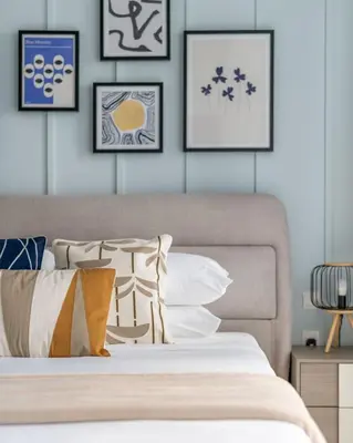 a bedroom with a bed with framed pictures on the wall at GuestReady - A Sanctuary Above the Clouds in Dubai