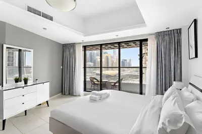 a bedroom with a white bed and a large window at Stylish Studio in Prime Location in Dubai