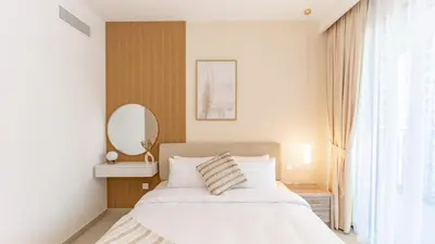 a bedroom with a white bed and a mirror at Burj Khalifa view with Grass Turf Balcony-Downtown by Tanami Holiday Homes in Dubai