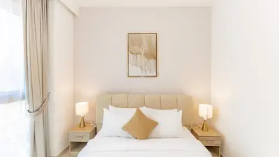 a bedroom with a bed with white sheets and pillows at Burj Khalifa view with Grass Turf Balcony-Downtown by Tanami Holiday Homes in Dubai