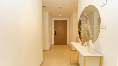 a bathroom with a mirror and a sink and a hallway at Burj Khalifa view with Grass Turf Balcony-Downtown by Tanami Holiday Homes in Dubai