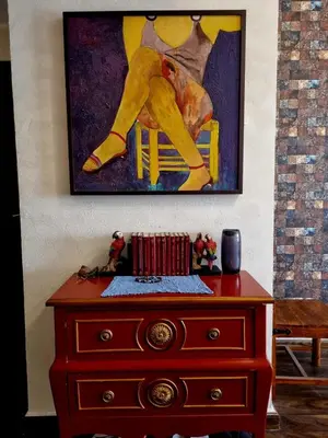 a painting of a man sitting on a chair on a dresser at YALLA REMRAAM in Dubai