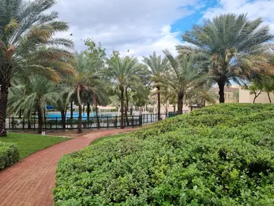 a path through a park with palm trees at YALLA REMRAAM in Dubai