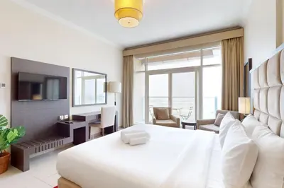 a bedroom with a white bed and a large window at Siraj Tower - Colourful Studio in Dubai