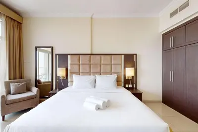 a bedroom with a large bed with two towels on it at Siraj Tower - Colourful Studio in Dubai