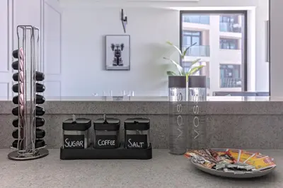 a kitchen with a counter with two black containers at Luxurious 4BR Apartment w/ Prime Burj Khalifa View in Dubai