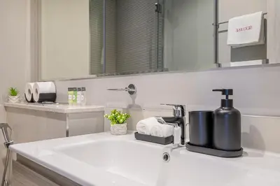 a bathroom with a sink with a soap dispenser on it at Modern Brand New 1 BR Apartment in ZADA Tower in Dubai