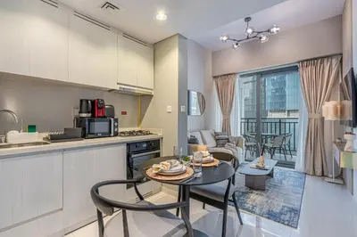 a kitchen and living room with a table and chairs at Modern Brand New 1 BR Apartment in ZADA Tower in Dubai
