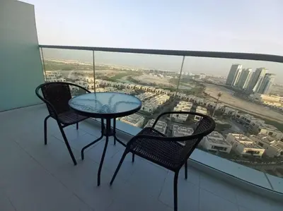 a table and two chairs on a balcony with a view at Furnished Studio in Damac Hills in Dubai