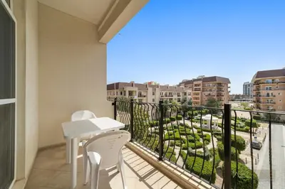 a balcony with a table and chairs and a view of a city at WelHome - Stylish Studio with Park Views in Regent House 2 in Dubai