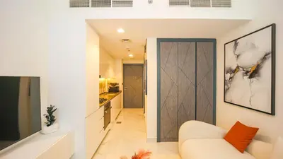a living room with a white couch and a kitchen at Magnificent studio-One of kind in Dubai in Dubai
