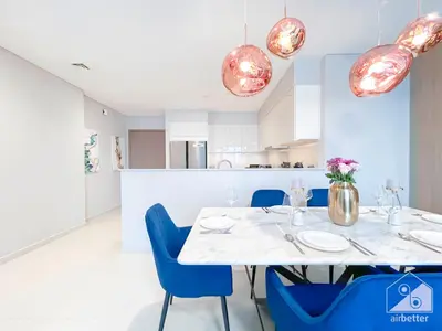 a dining room with a white table and blue chairs at Spacious 3.5 Bedroom Apartment in Burj Royale in Dubai