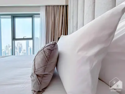 a bedroom with white pillows and a large window at Spacious 3.5 Bedroom Apartment in Burj Royale in Dubai