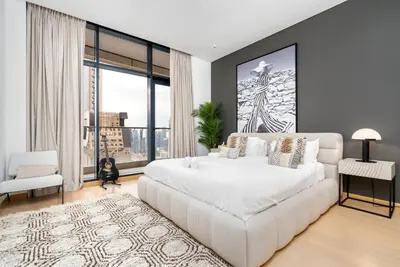 a bedroom with a white bed and a large window at Luxe 6BR Penthouse with Burj View & Private Cinema in Dubai