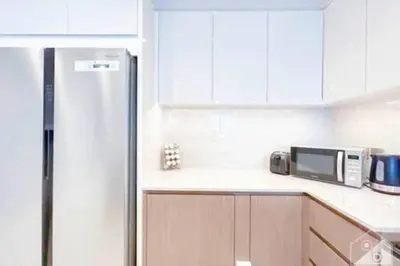 a kitchen with a refrigerator and a microwave at Luxury Burj Royale 4Bed Balcony Burj Khalifa View in Dubai