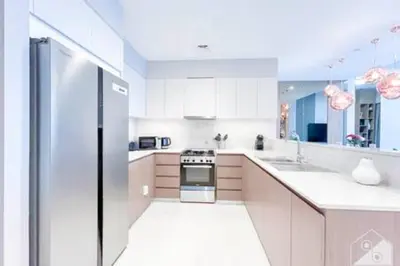 a white kitchen with a refrigerator and a sink at Luxury Burj Royale 4Bed Balcony Burj Khalifa View in Dubai