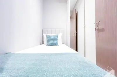 a white bedroom with a bed with a blue pillow at Luxury Burj Royale 4Bed Balcony Burj Khalifa View in Dubai