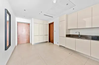 an empty kitchen with white cabinets and a sink at Stylish 1 BR in Dubai Marina in Dubai
