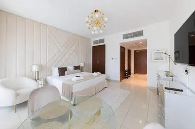 a white bedroom with a bed and a bathroom at Downtown Studio next to Dubai Opera, Dubai Mall in Dubai