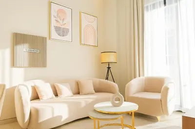 a living room with a white couch and a chair at Luxe 1BR 15mins-Beach Best Infinity Pool -Jumeirah Village Circle, JVC ,Dubai in Dubai