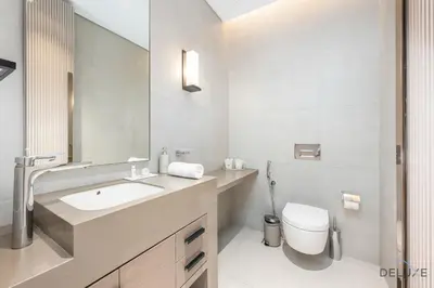 a bathroom with a sink and a toilet and a mirror at Ultra Luxurious 4BR with Assistant Room in The Address Residences, JBR by Deluxe Holiday Homes in Dubai