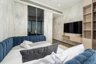 a bedroom with a blue bed and a tv at Ultra Luxurious 4BR with Assistant Room in The Address Residences, JBR by Deluxe Holiday Homes in Dubai