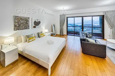 a bedroom with a large white bed and a couch at Jumeirah Beach Residence - Rimal 3, Dubai Marina in Dubai