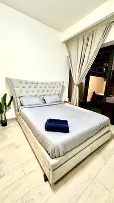 a bedroom with a white bed with a blue towel on it at Luxury Studio with big balcony Azizi Riviera Meydan in Dubai