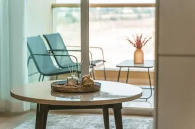 a coffee table in a room with two chairs and a window at Cozy Chic Studio with Balcony The Greens Dubai in Dubai