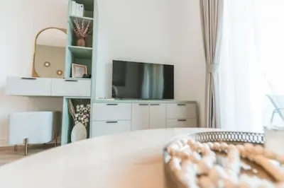 a living room with a table and a tv at Cozy Chic Studio with Balcony The Greens Dubai in Dubai