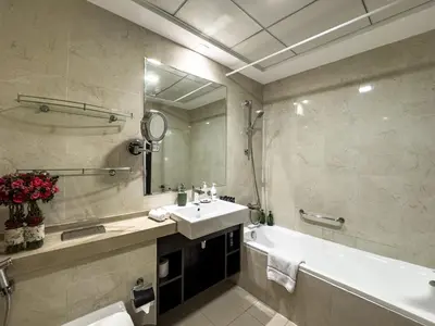 a bathroom with a sink and a tub and a mirror at SettlerHomes- Breathtaking 2BR Marina High-Floor in Dubai